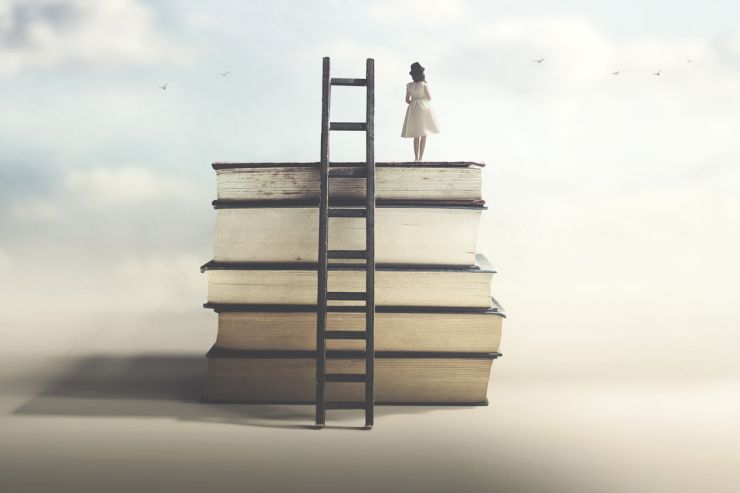 woman standing on stack of books.jpg